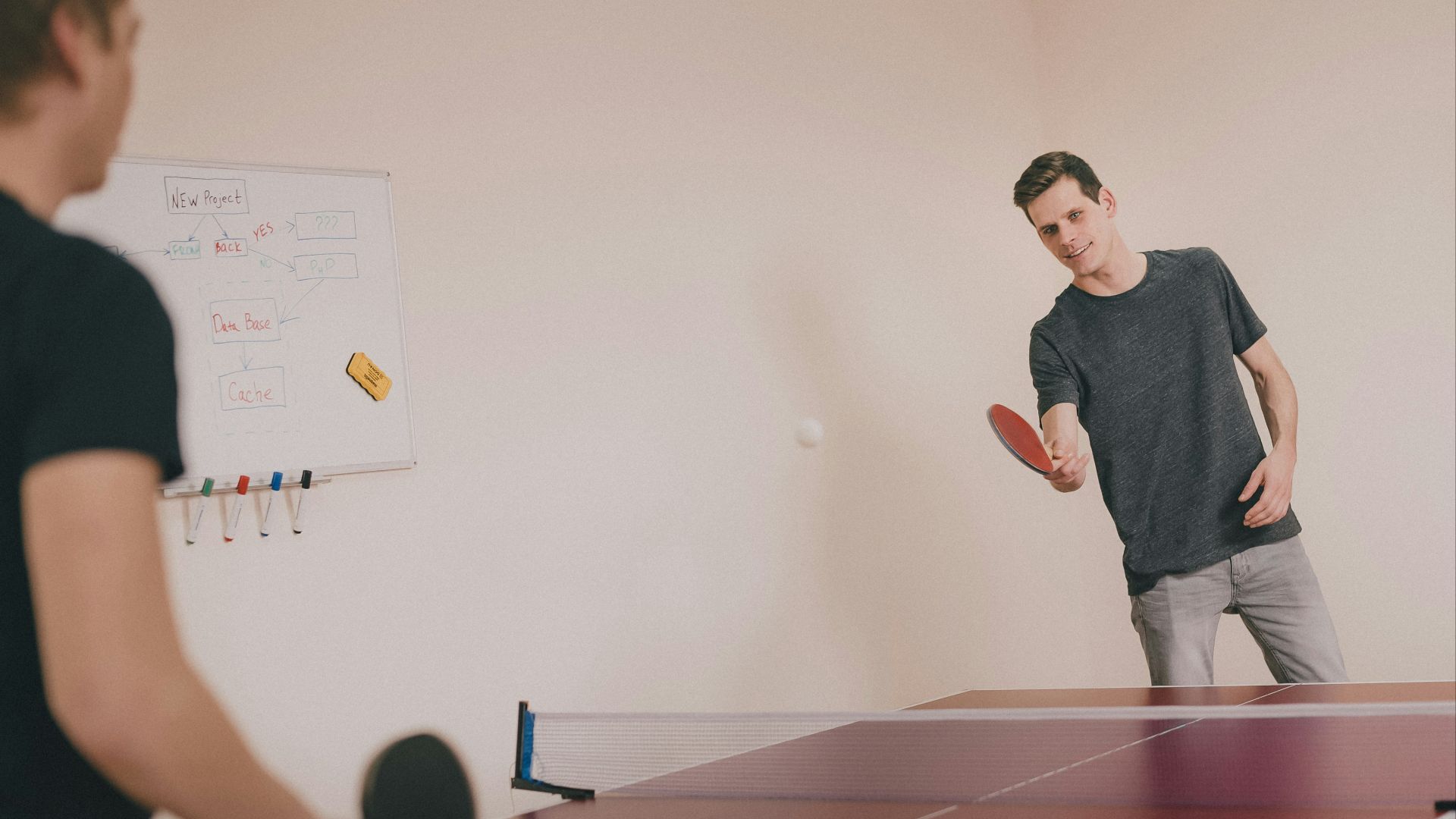 two men playing ping-pong inside room