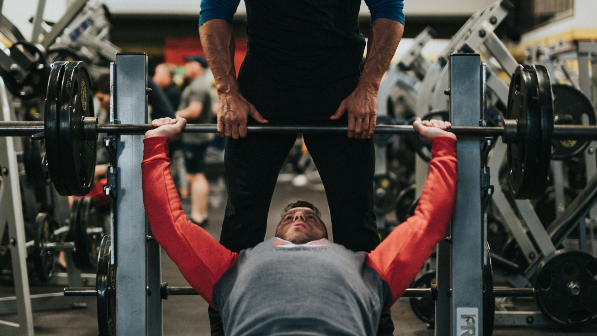 man in black crew neck t-shirt and gray pants sitting on black and red bench
