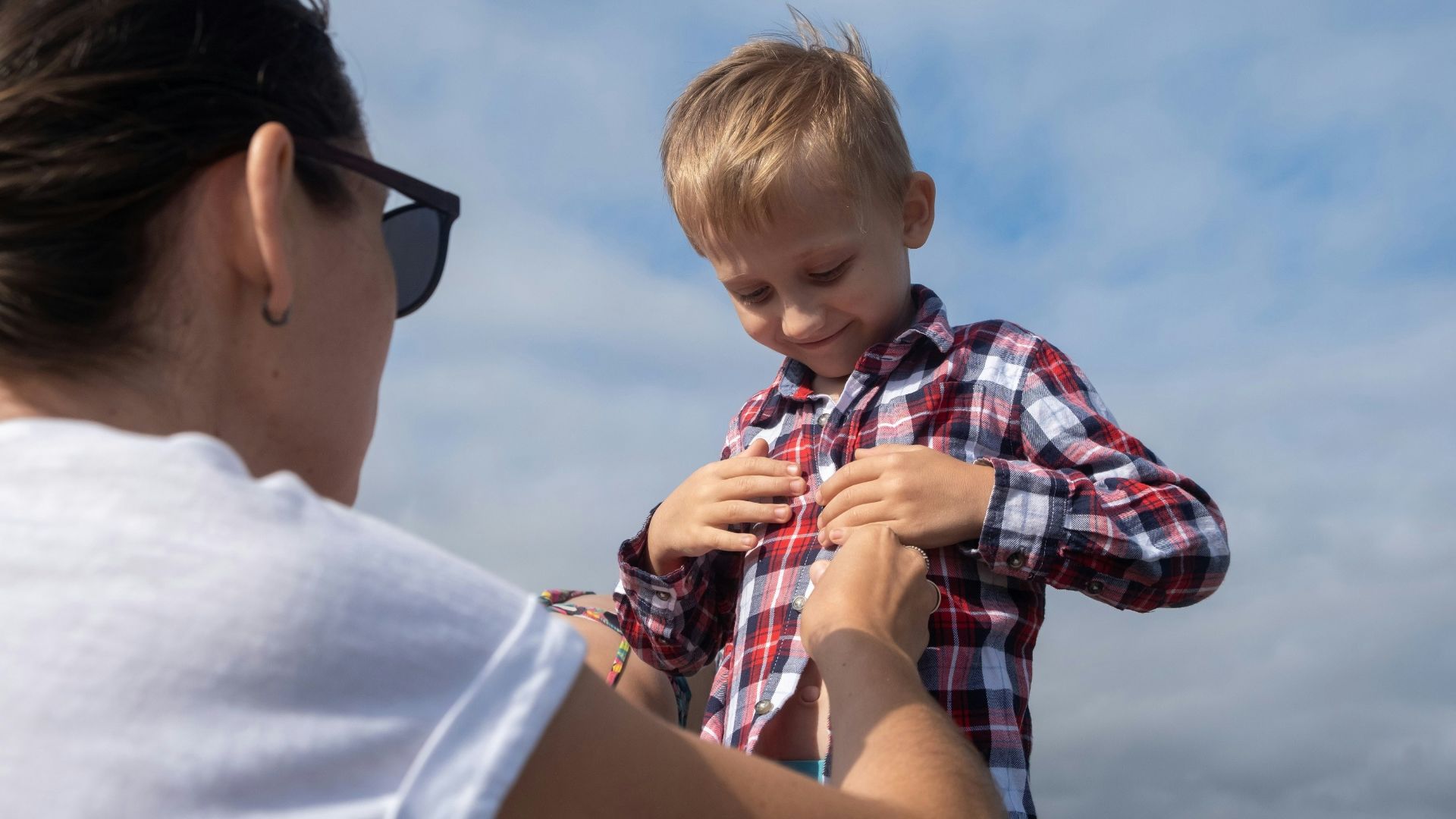A woman is holding a young boy on a boat