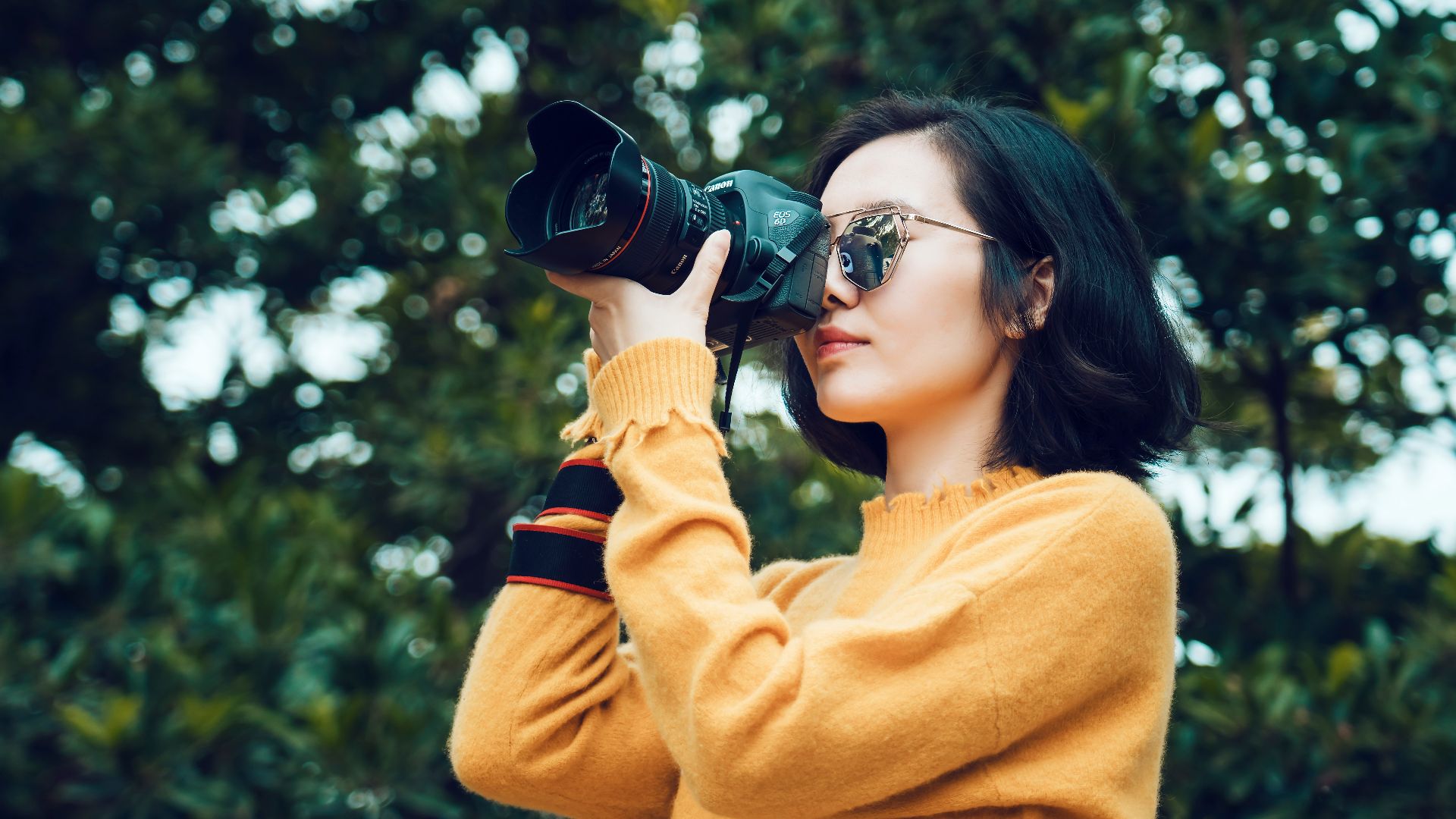 woman taking photo near tree