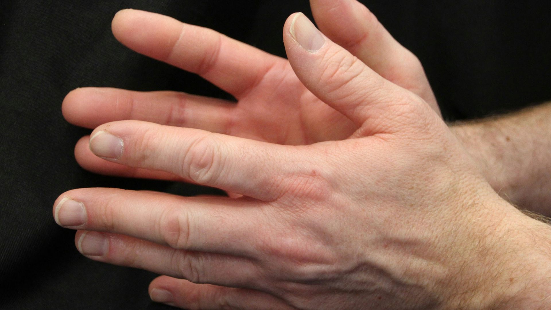 a close up of a person holding their hands together