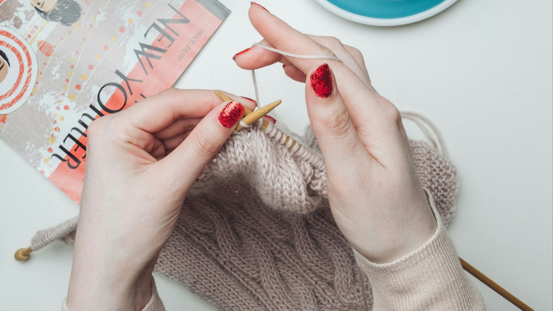person knitting beige garment