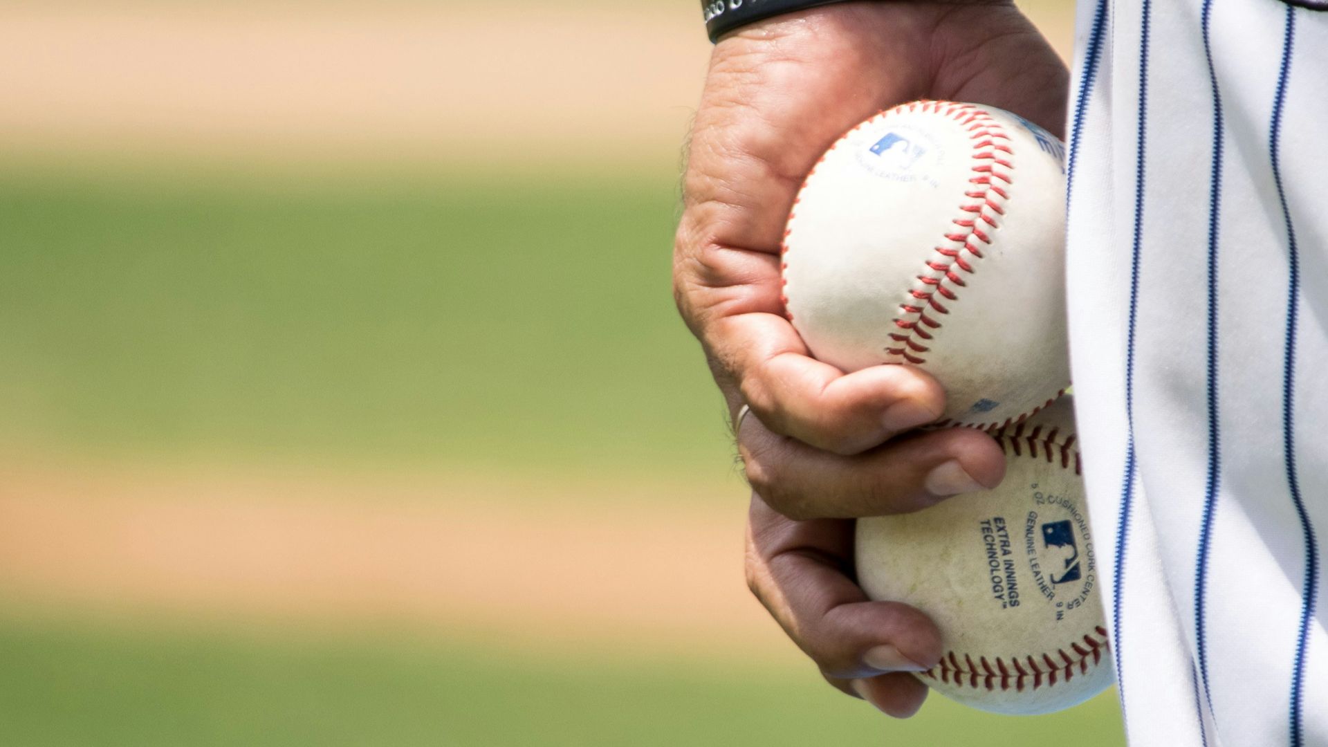 person holding two baseballs