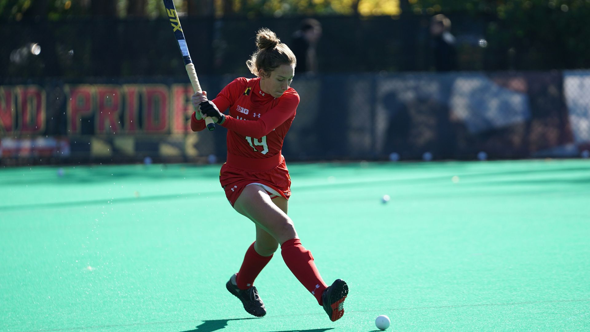 woman playing hockey on fields during daytime