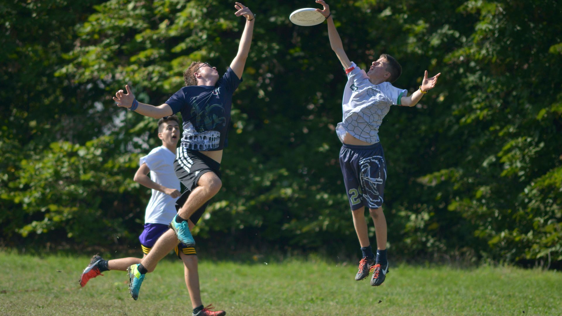 2 women playing soccer on green grass field during daytime