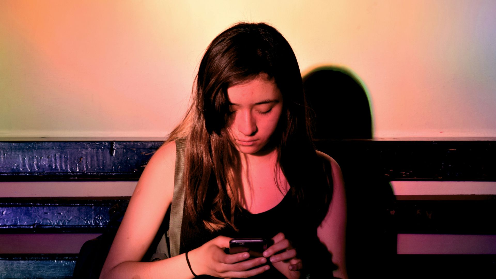 woman wearing black tank dress using smartphone