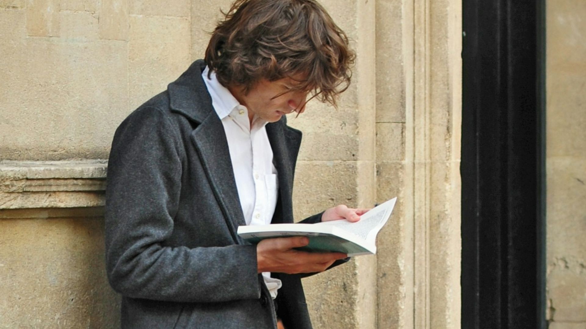 man sitting beside cup of coffee