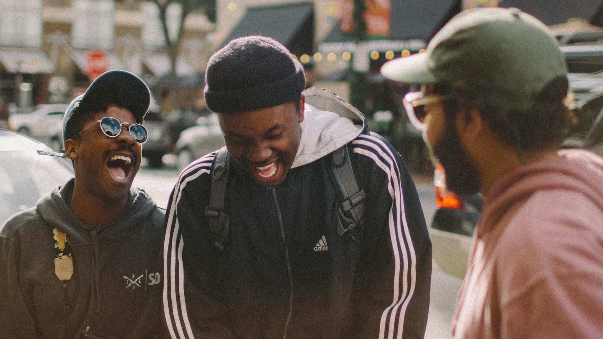 three men in jacket laughing at each other