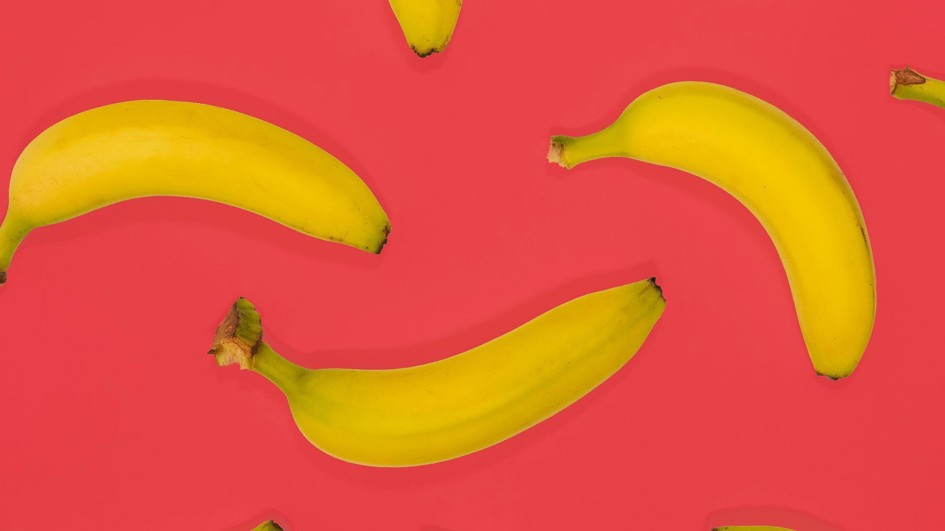 yellow banana fruits on pink surface