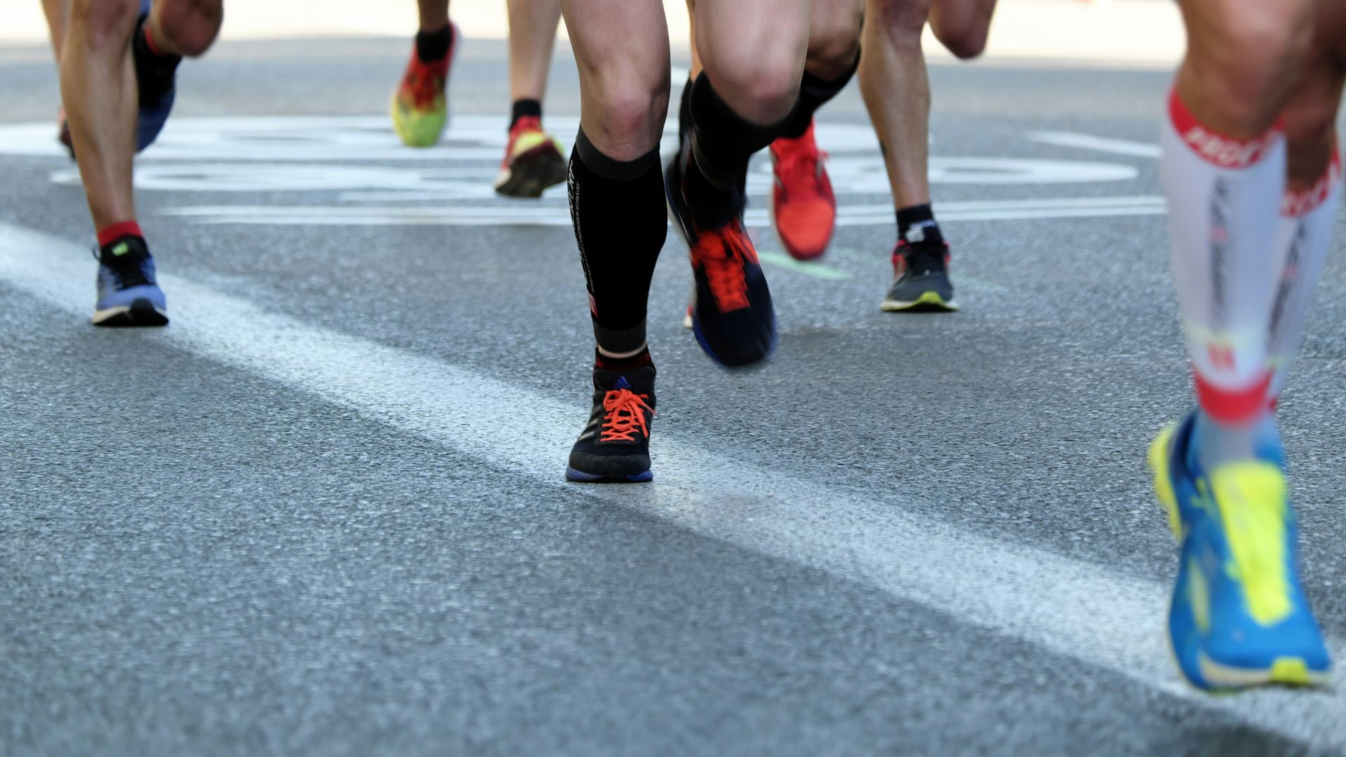 people running on gray asphalt road during daytime