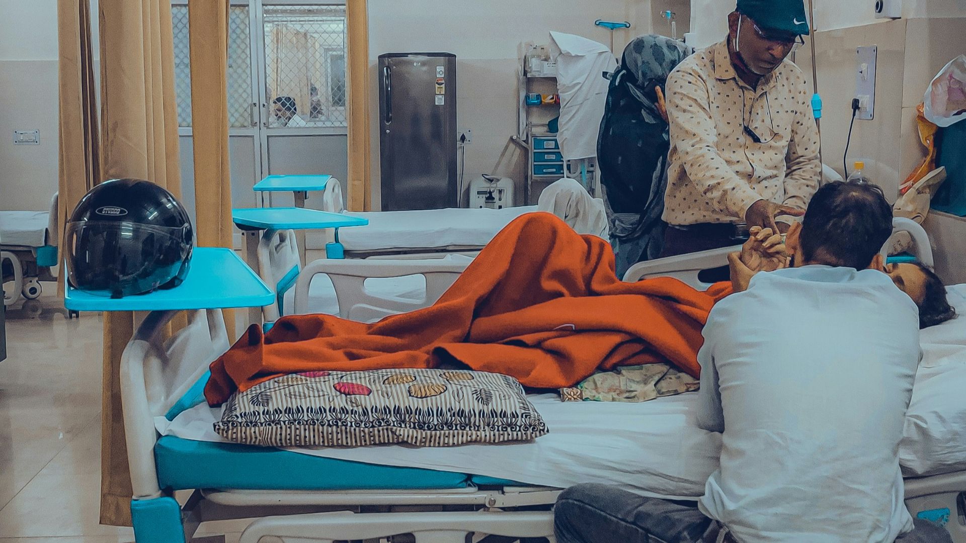 a group of people sitting around a hospital bed
