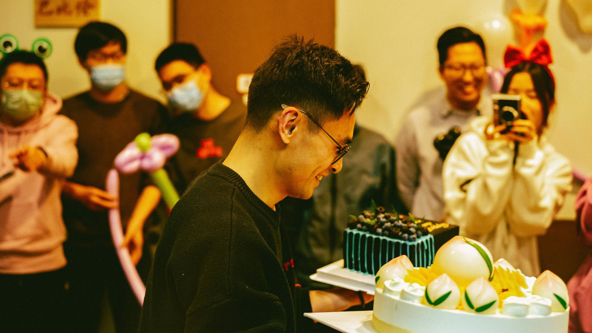 a group of people standing around a cake