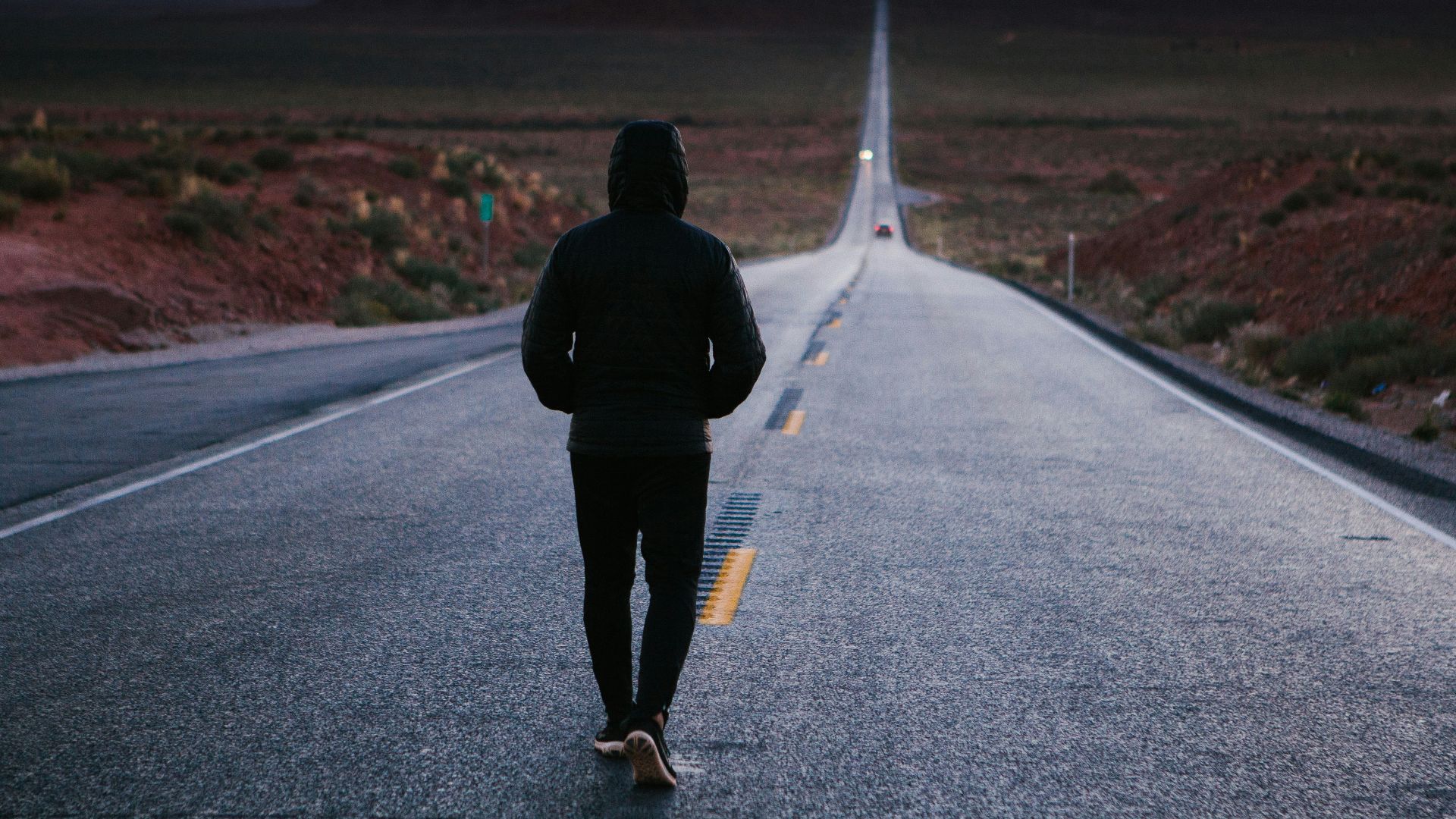 person walking in the center of the road