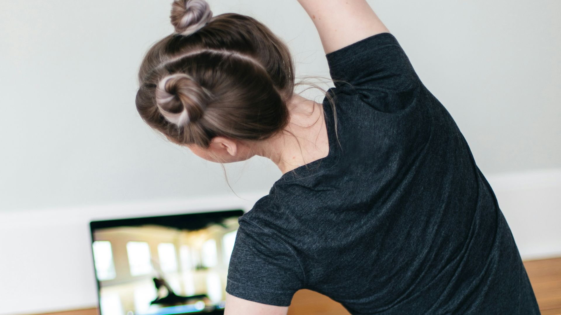 woman in black t-shirt and black pants lying on black yoga mat