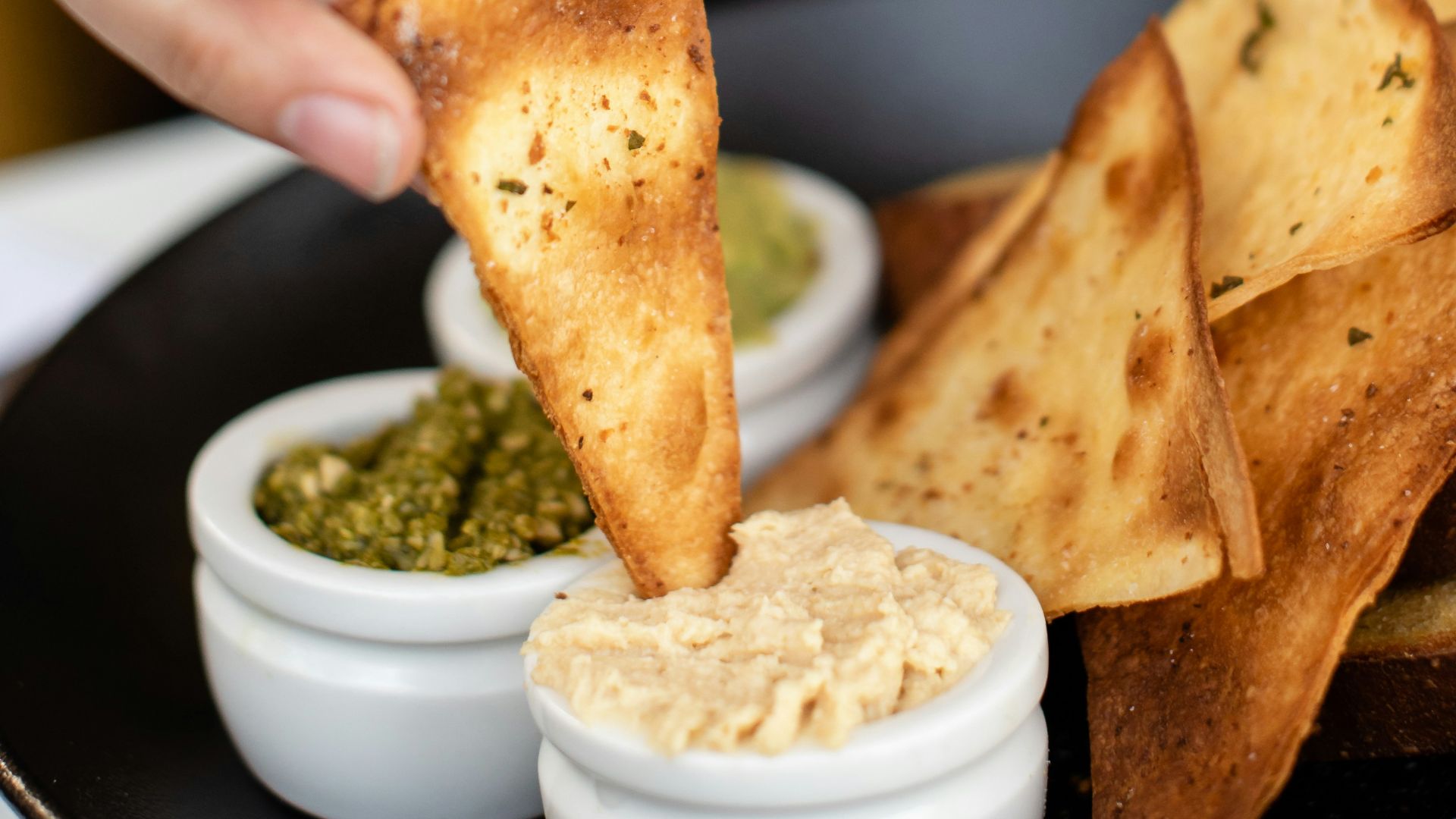 person eating nachos with sauce