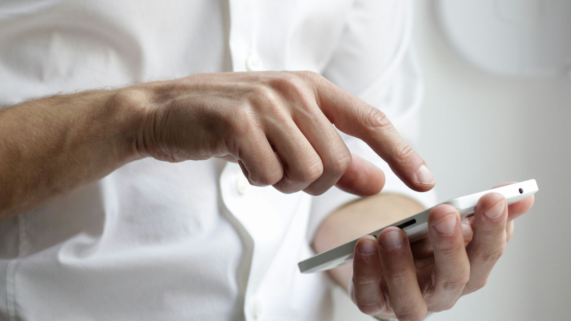 person holding white Android smartphone in white shirt