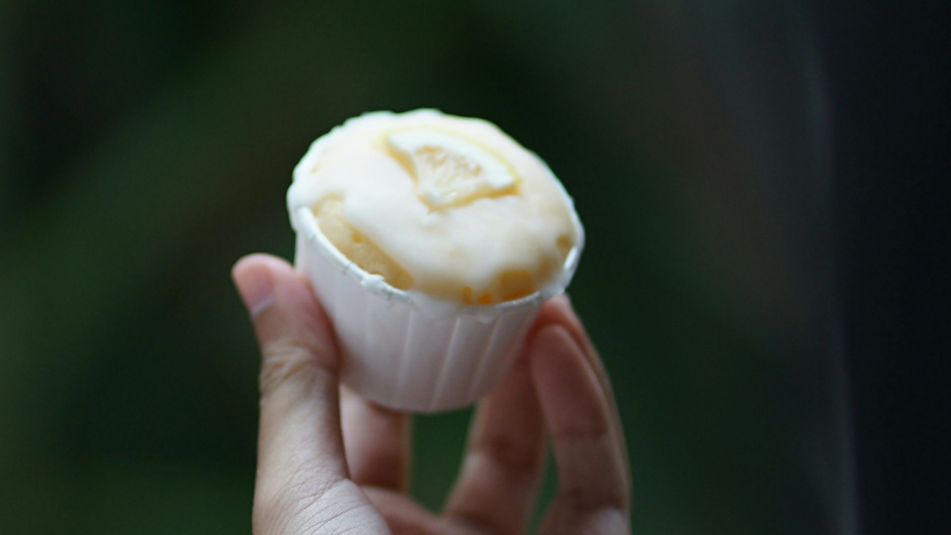 a person holding a cupcake in their hand