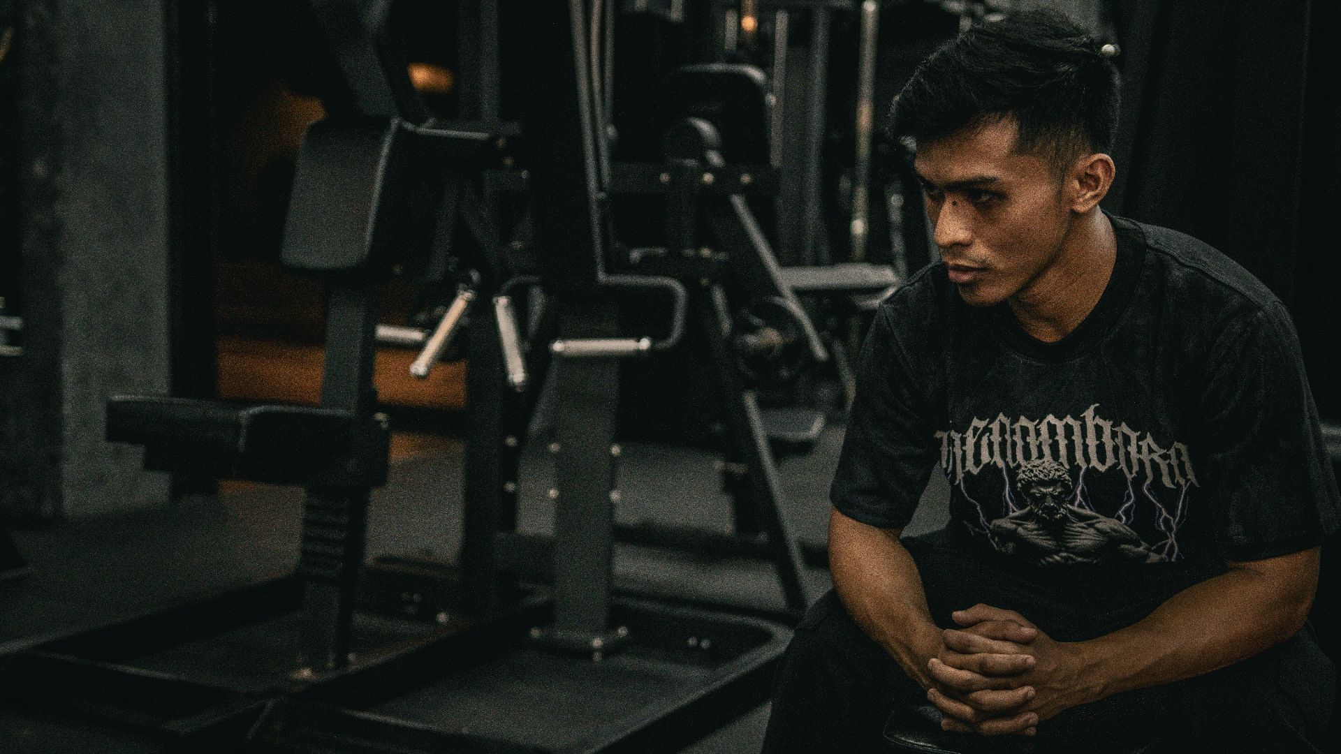 A man sitting on a bench in a gym