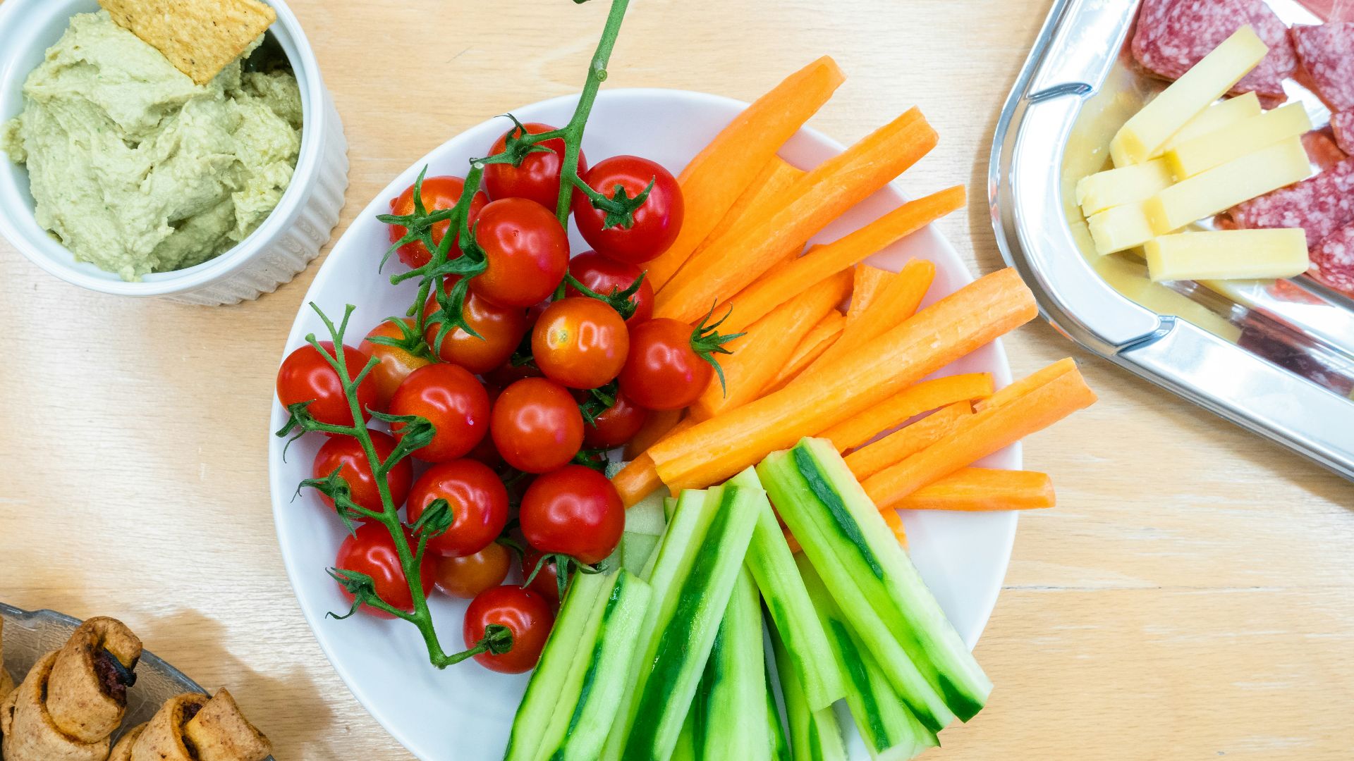 slices of carrots, zucchini, and cherry tomatoes on round white ceramic bowl