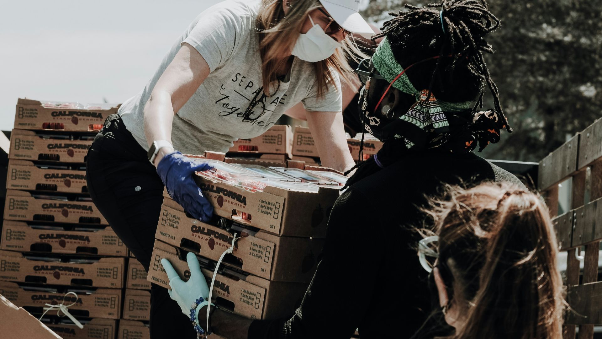 woman in white t-shirt and blue denim jeans sitting on brown cardboard box