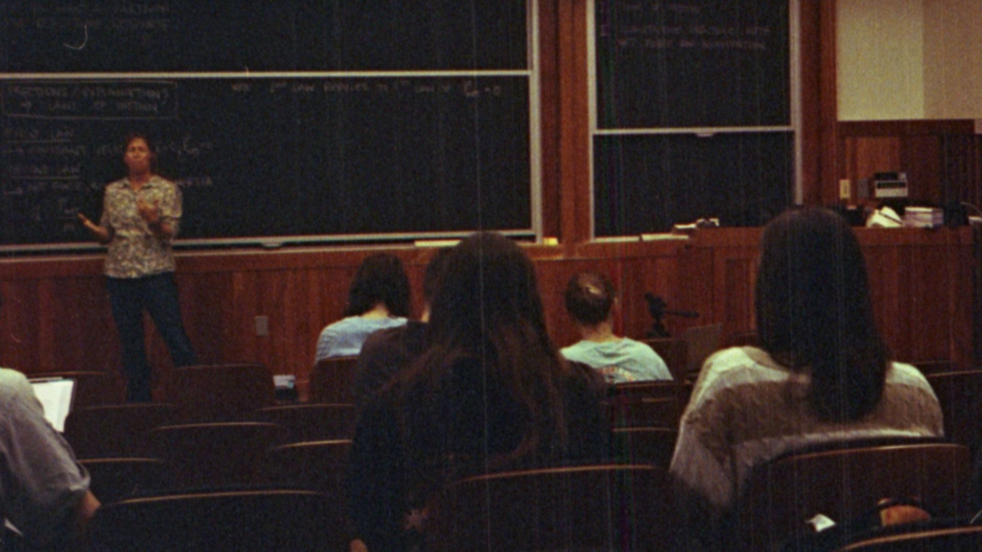 A group of people sitting in front of a blackboard