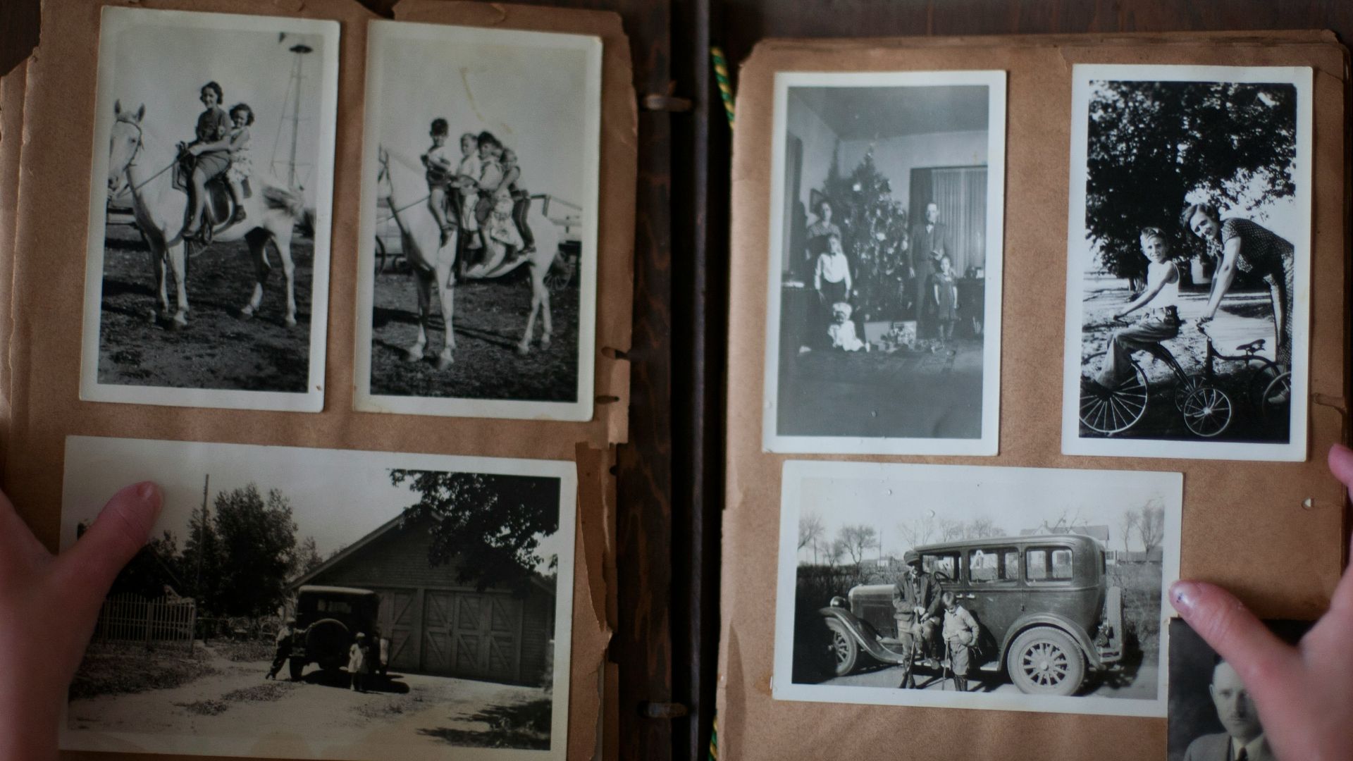 person opening photo album displaying grayscale photos