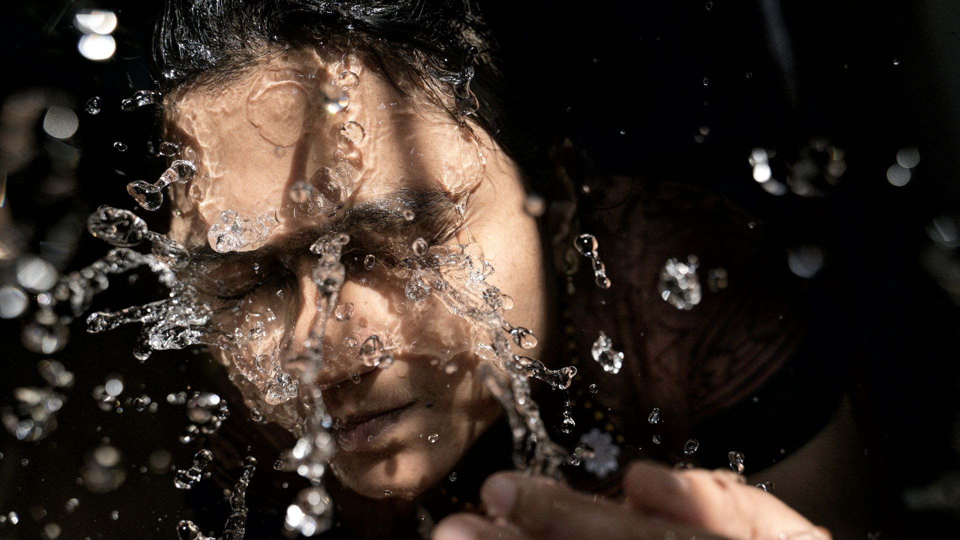 woman in black shirt with water droplets