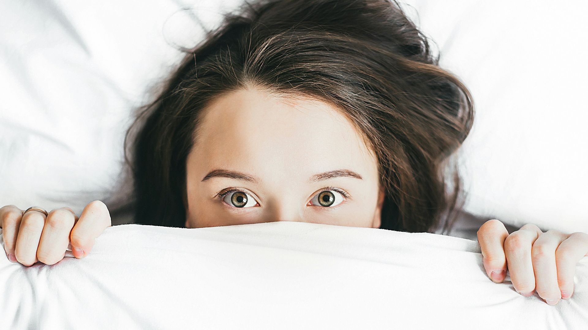 woman covering her face with blanket