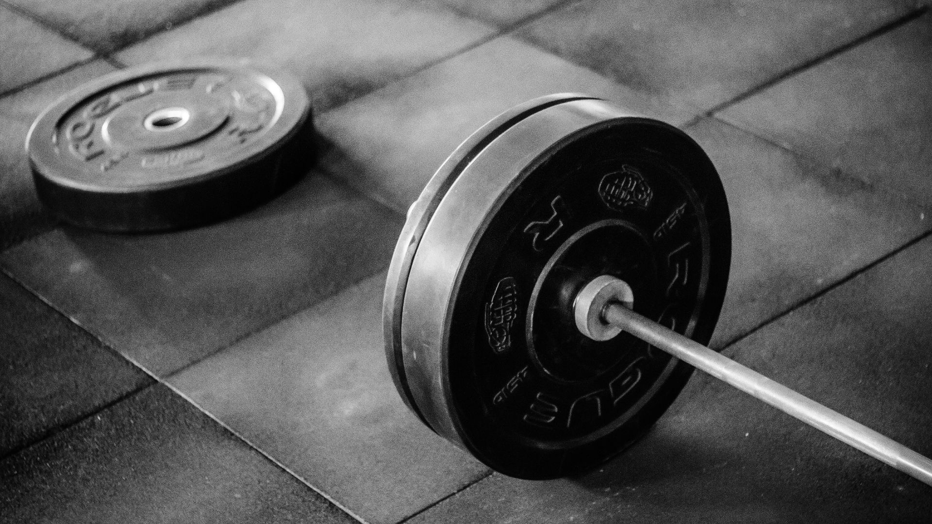 black barbell on tile flooring