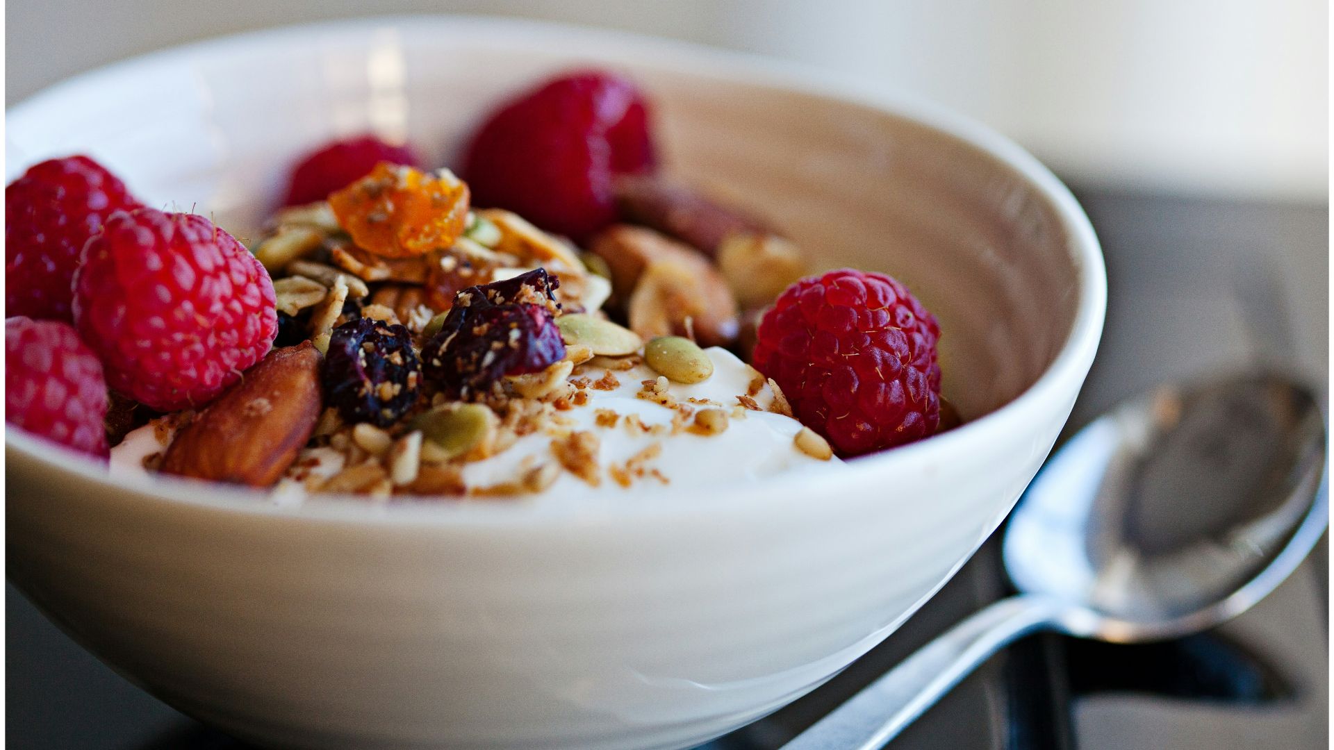 a bowl of granola with raspberries and nuts