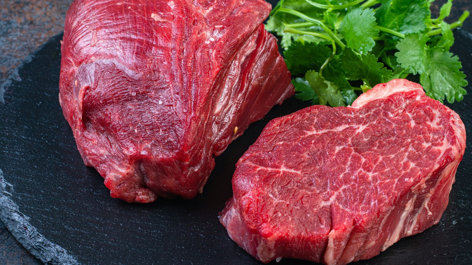 Two steaks on a plate with parsley