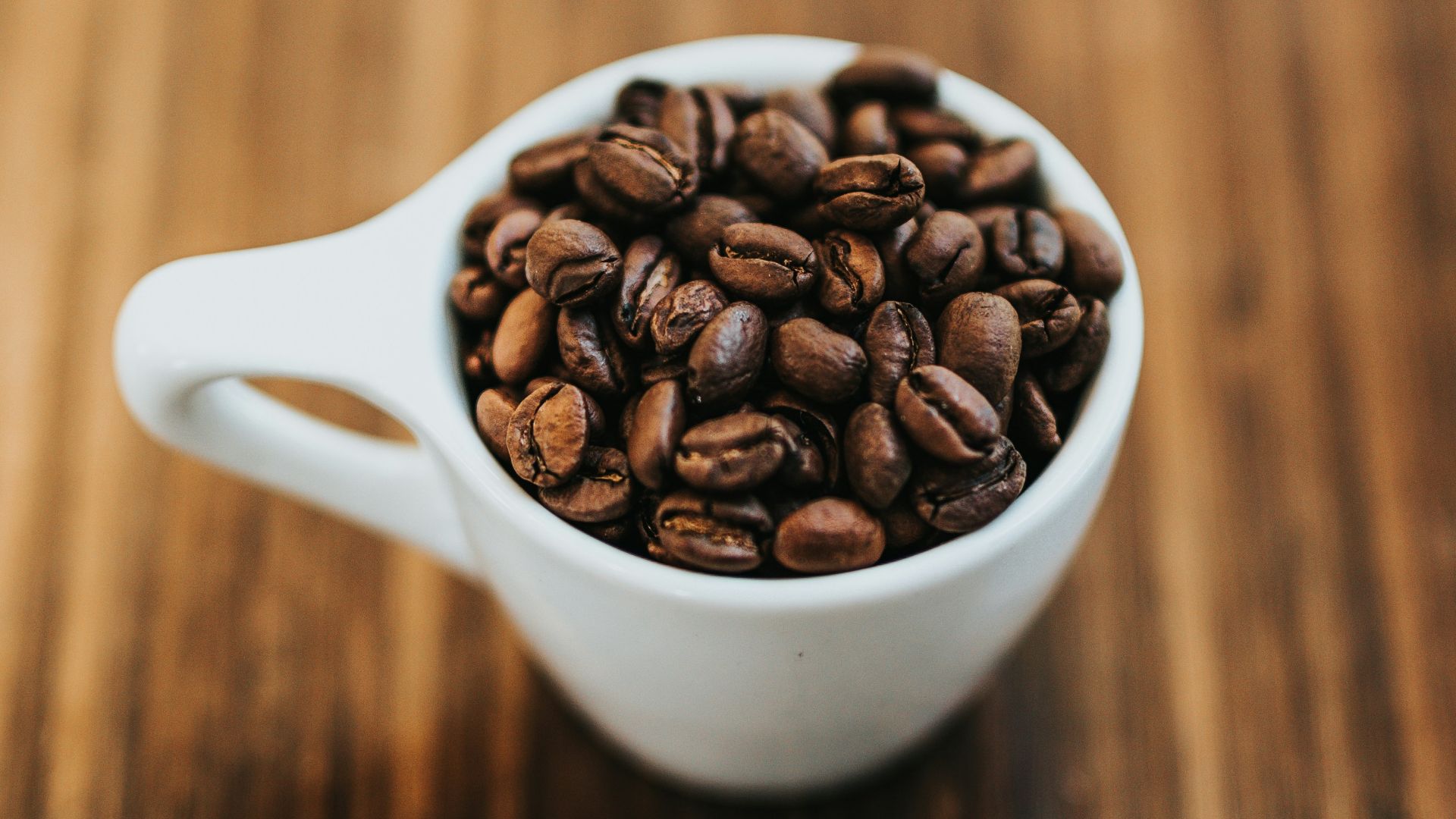 round white ceramic mug with coffee beans