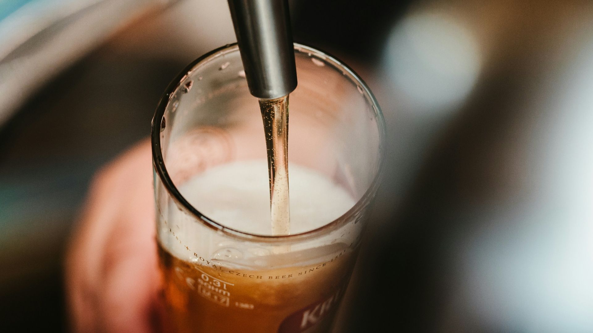 person filling clear glass with liquid