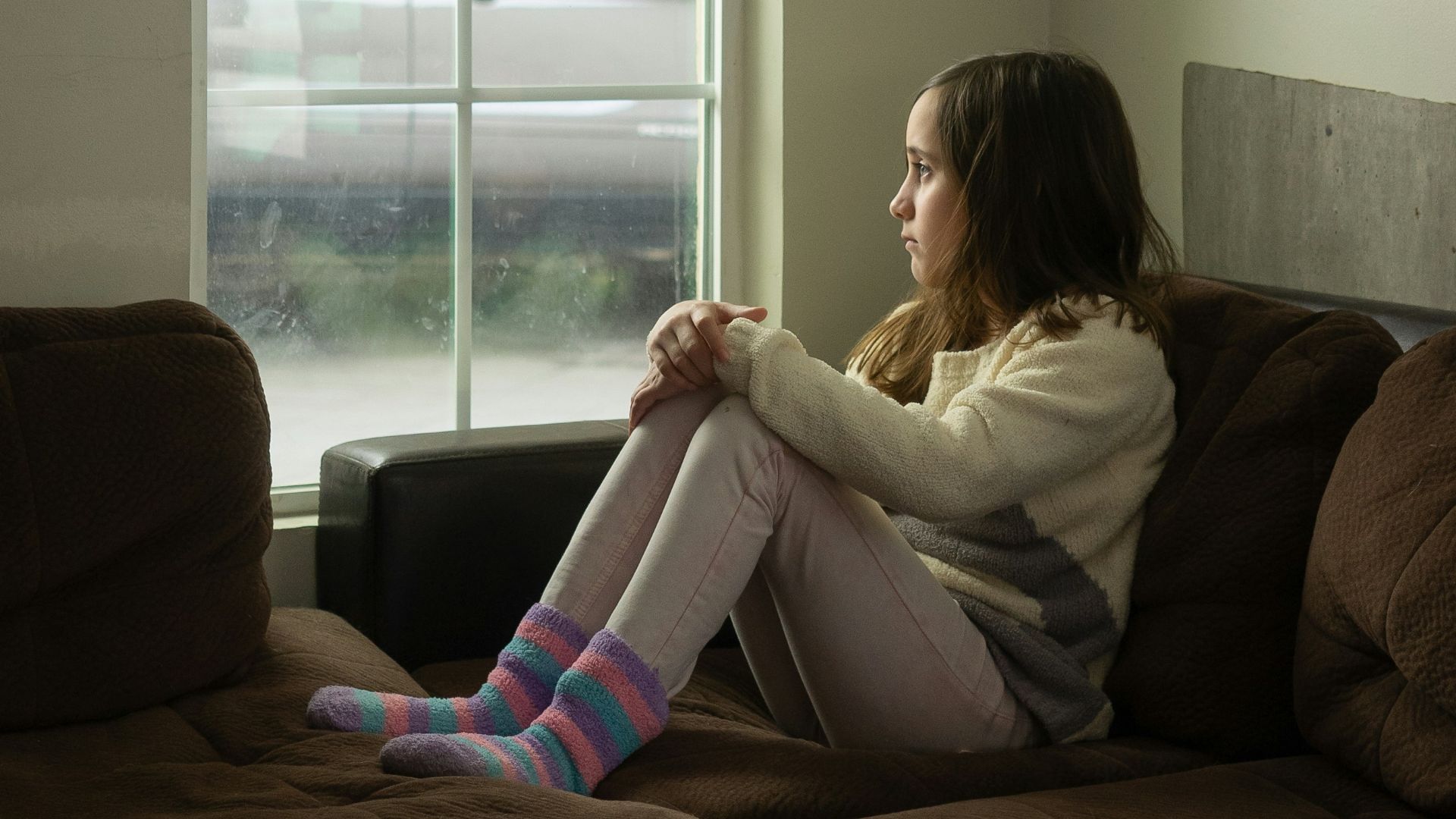 woman in white long sleeve shirt sitting on black couch