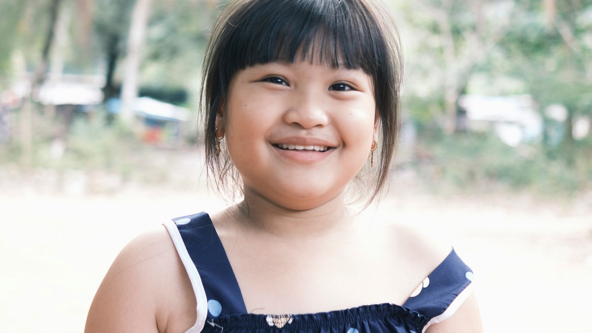 a little girl is smiling for the camera