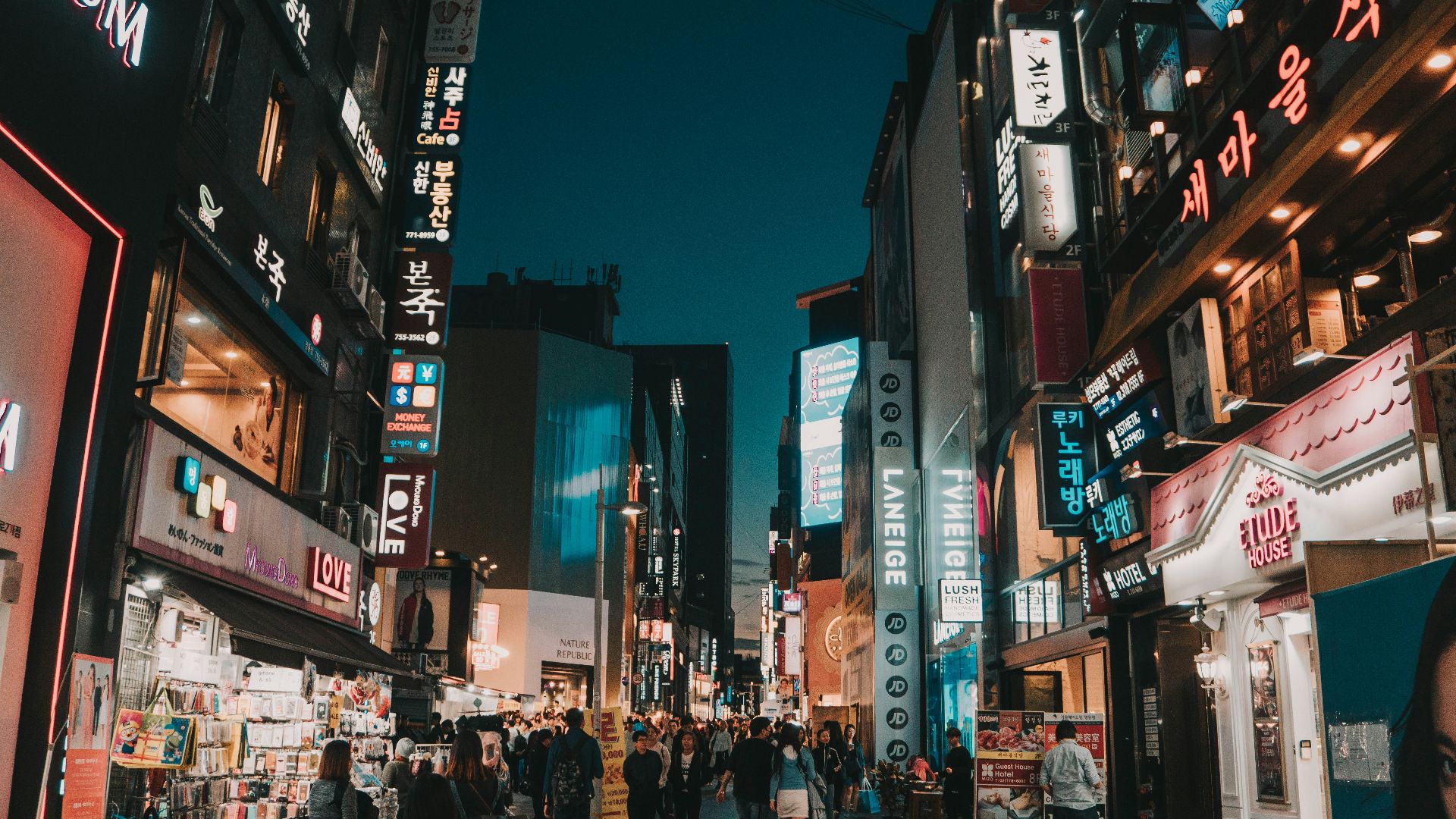 people walking between tall buildings