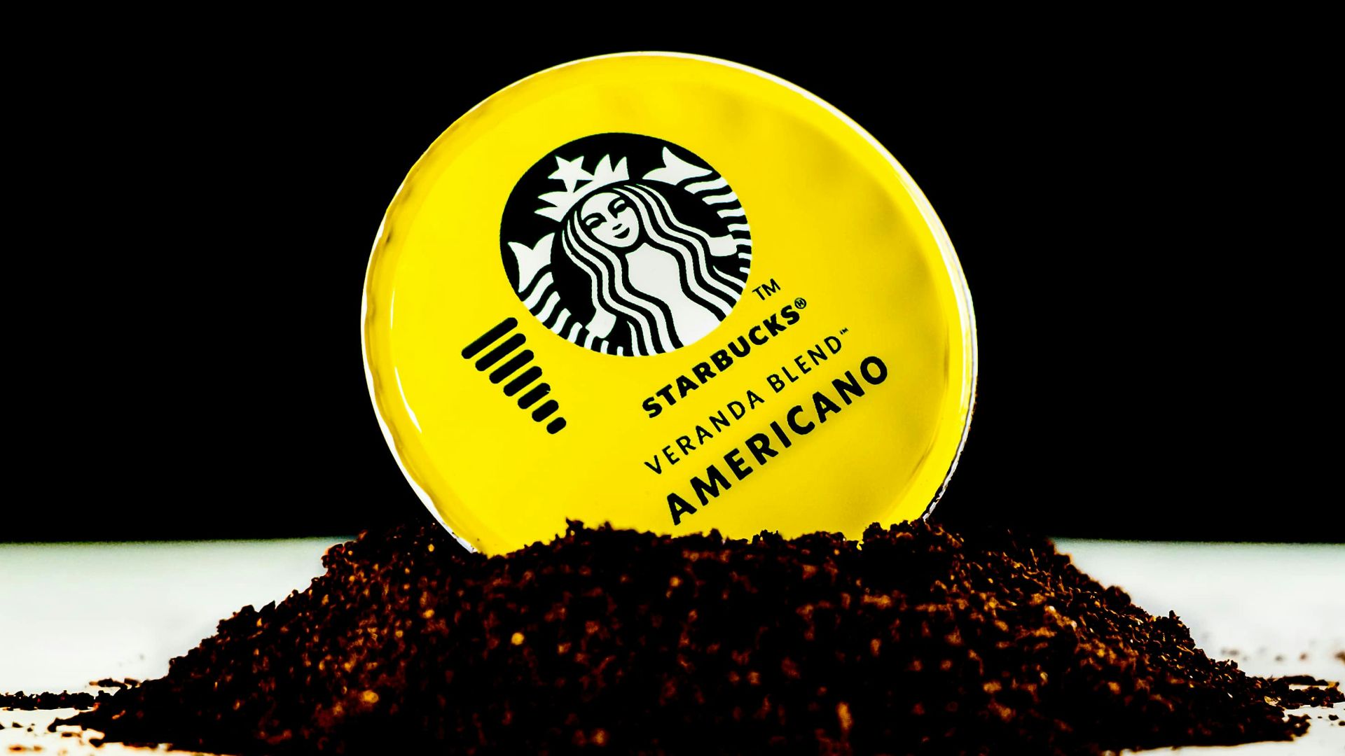 a yellow starbucks cup sitting on top of a pile of dirt