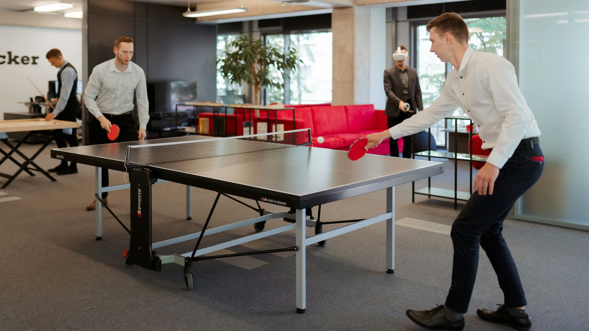 a man is playing ping pong in an office