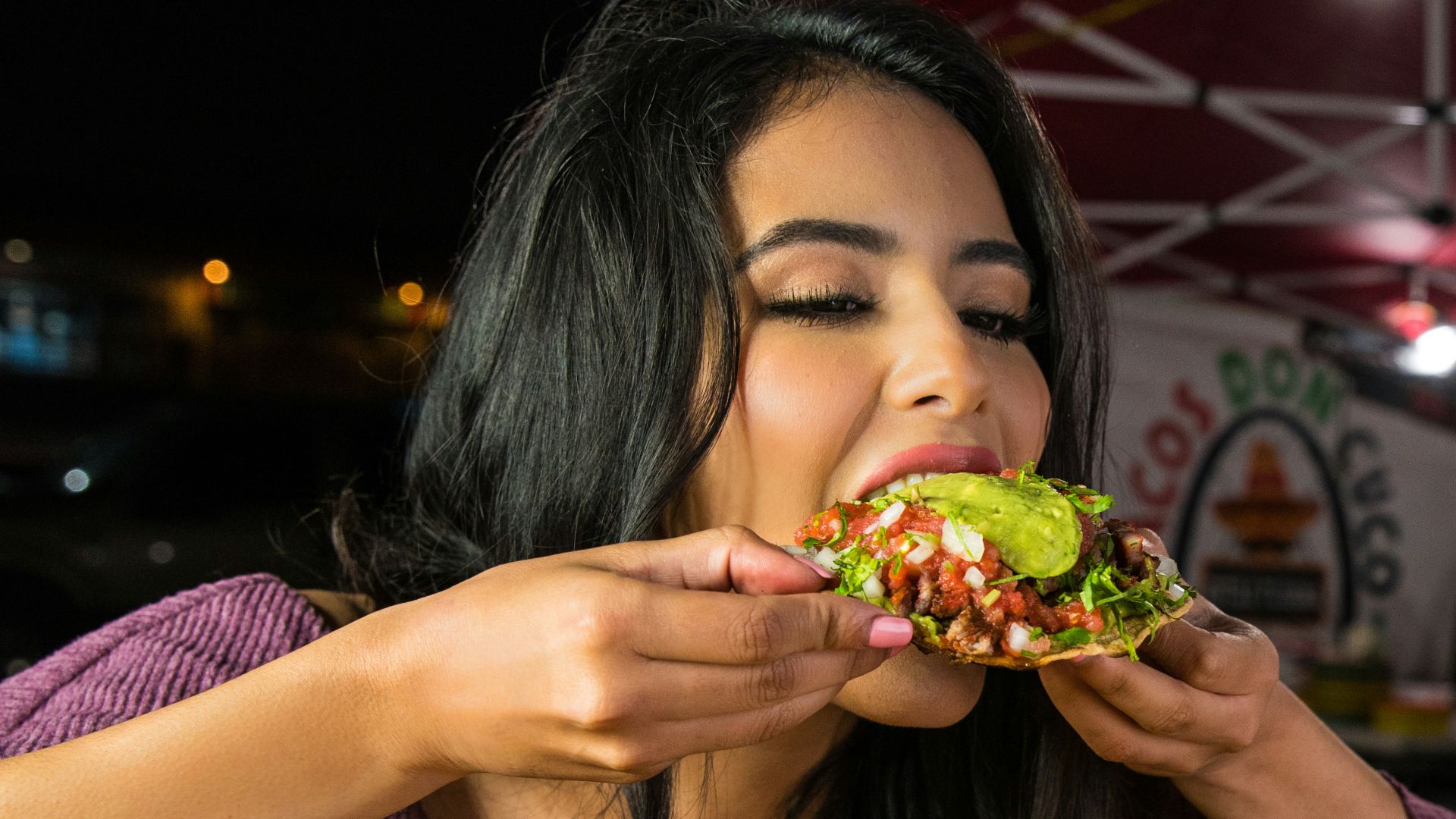 woman in purple shirt holding green and yellow floral ceramic bowl