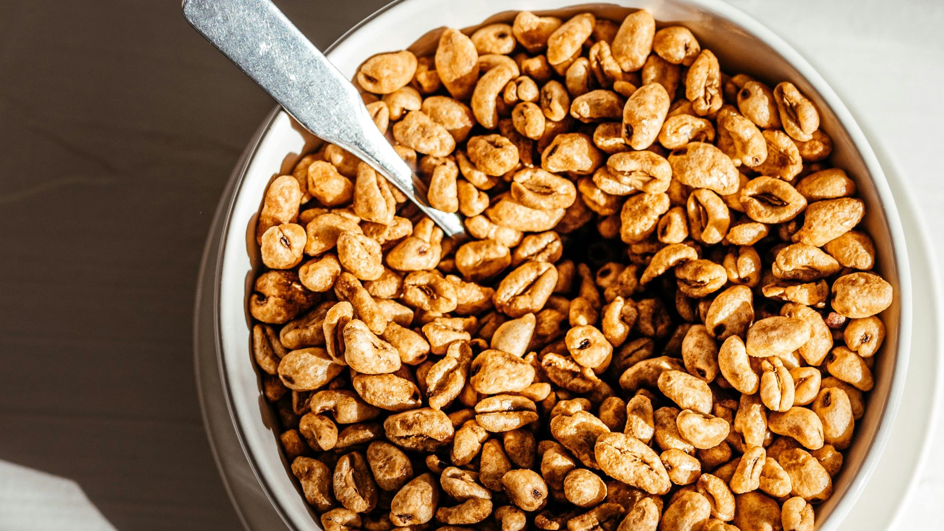 a bowl of nuts with a spoon in it