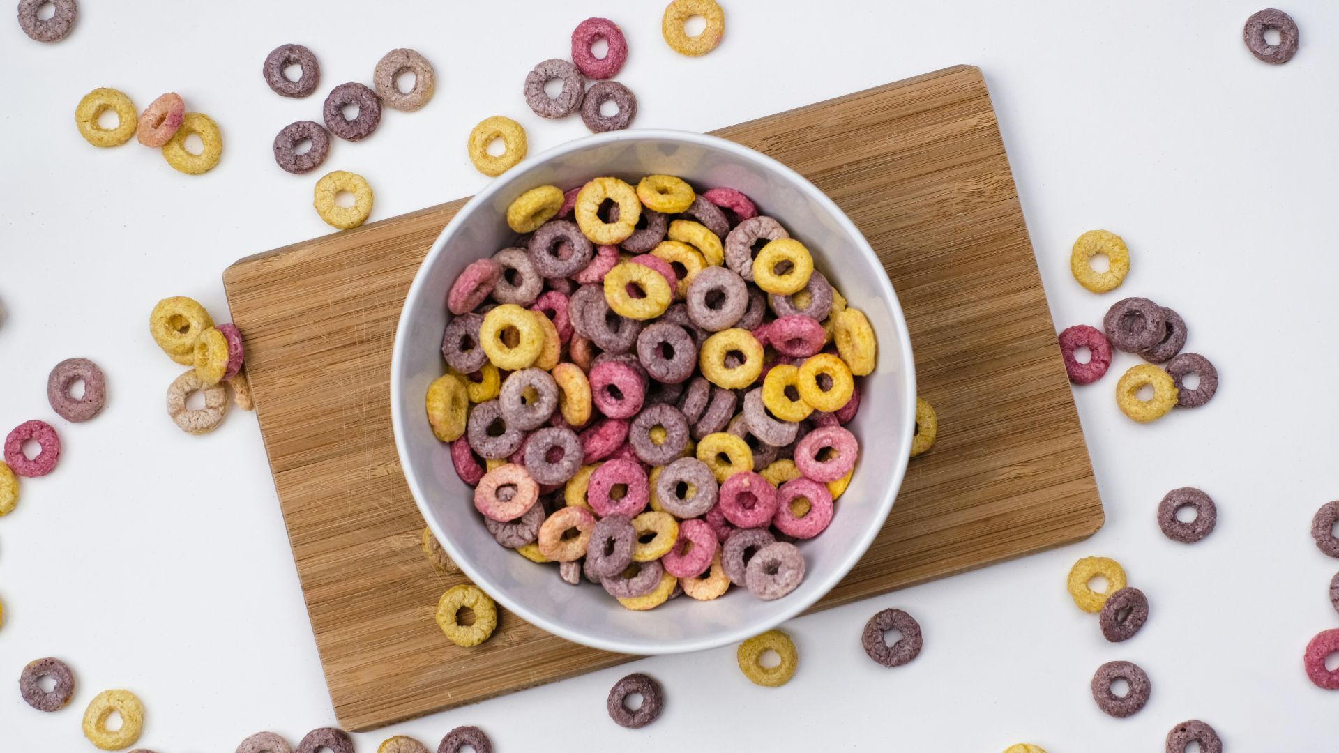 red and blue berries on white ceramic bowl on brown wooden chopping board