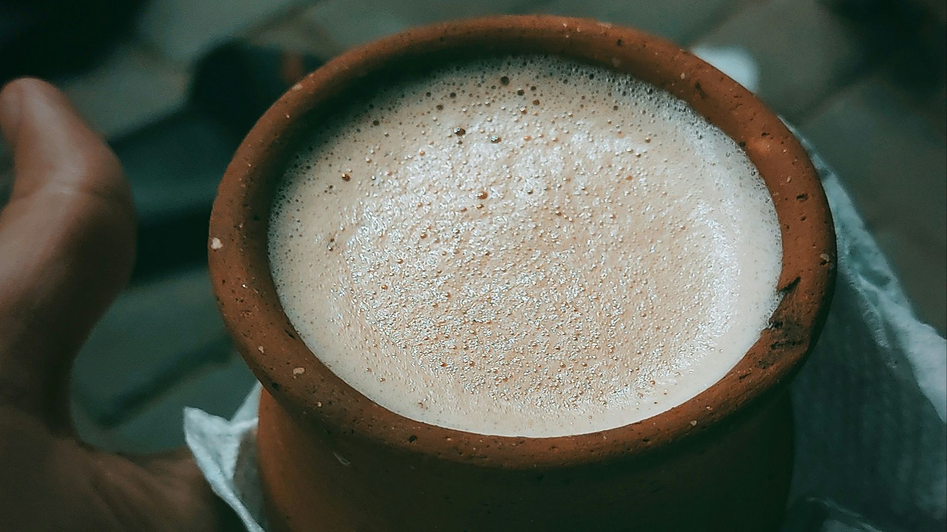 a hand holding a cup of coffee