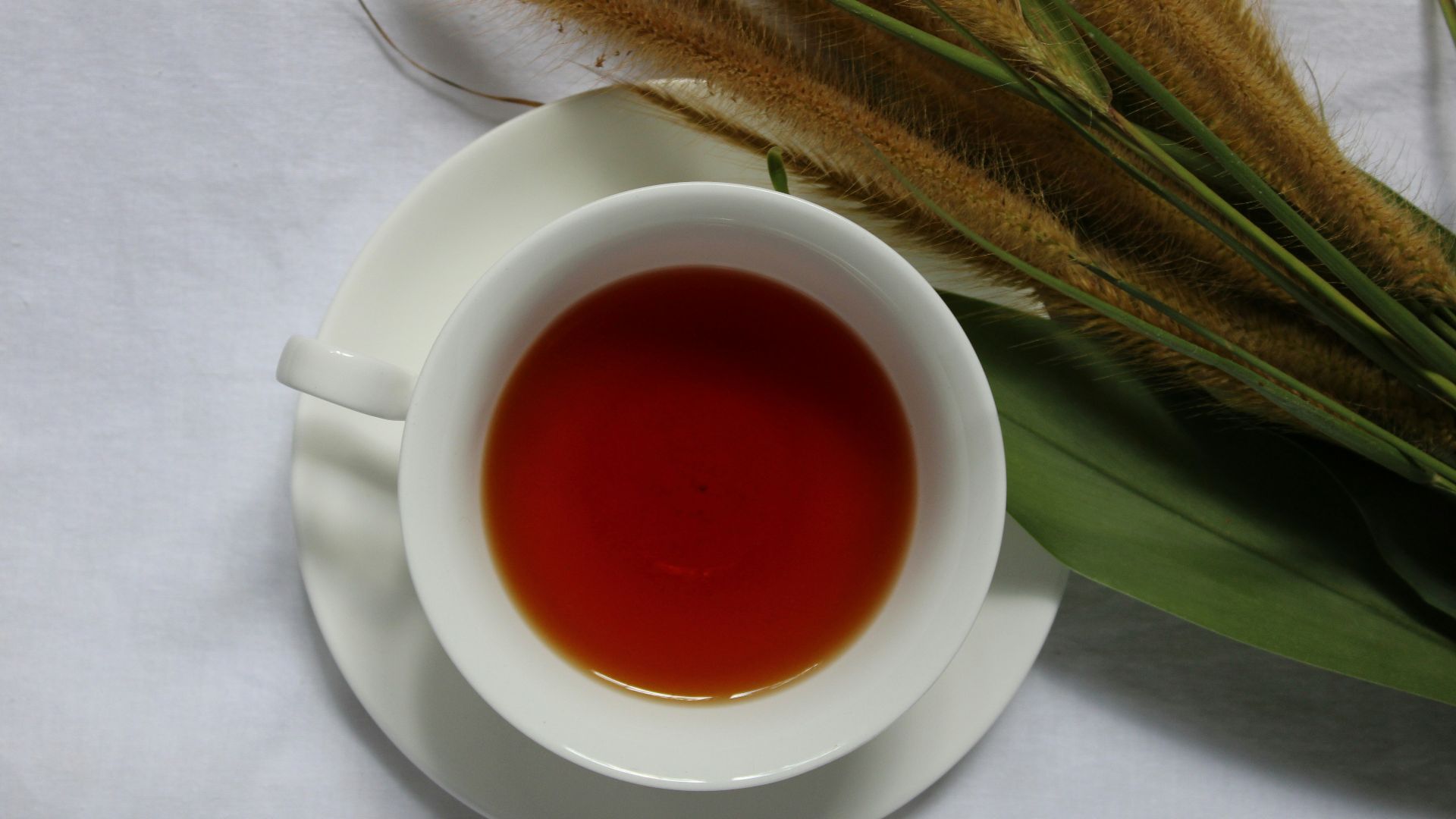 a cup of tea next to a bunch of grass