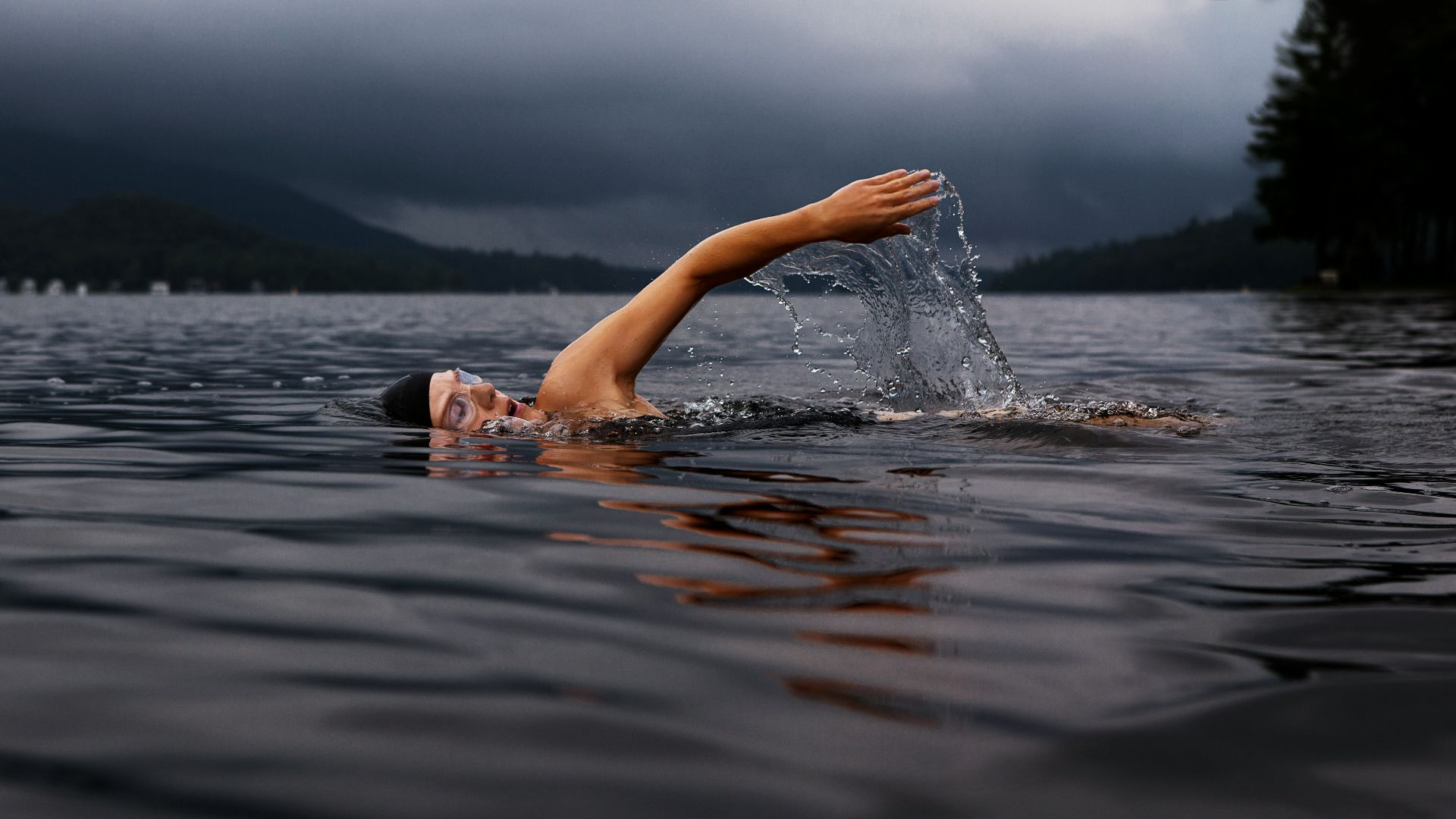 man swimming on body of water
