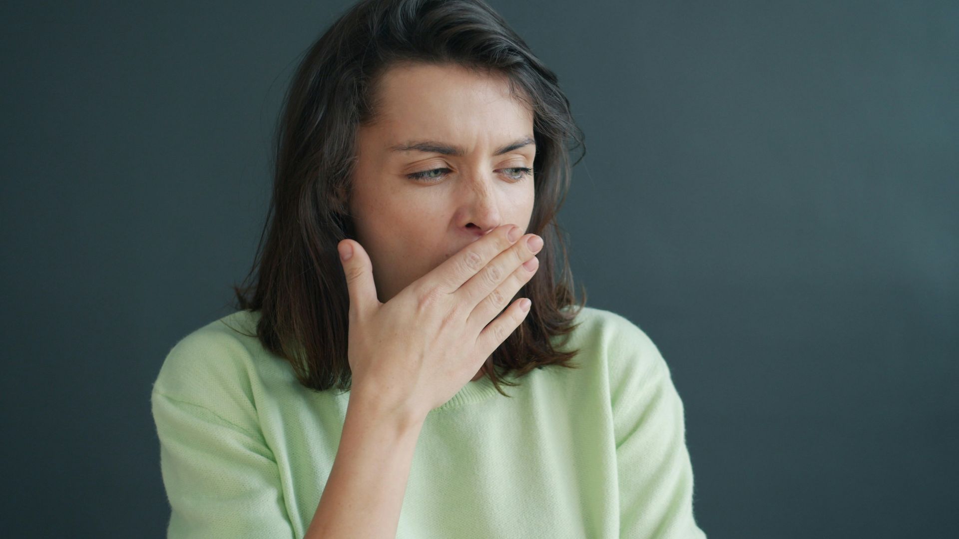 Woman covering her mouth with hand