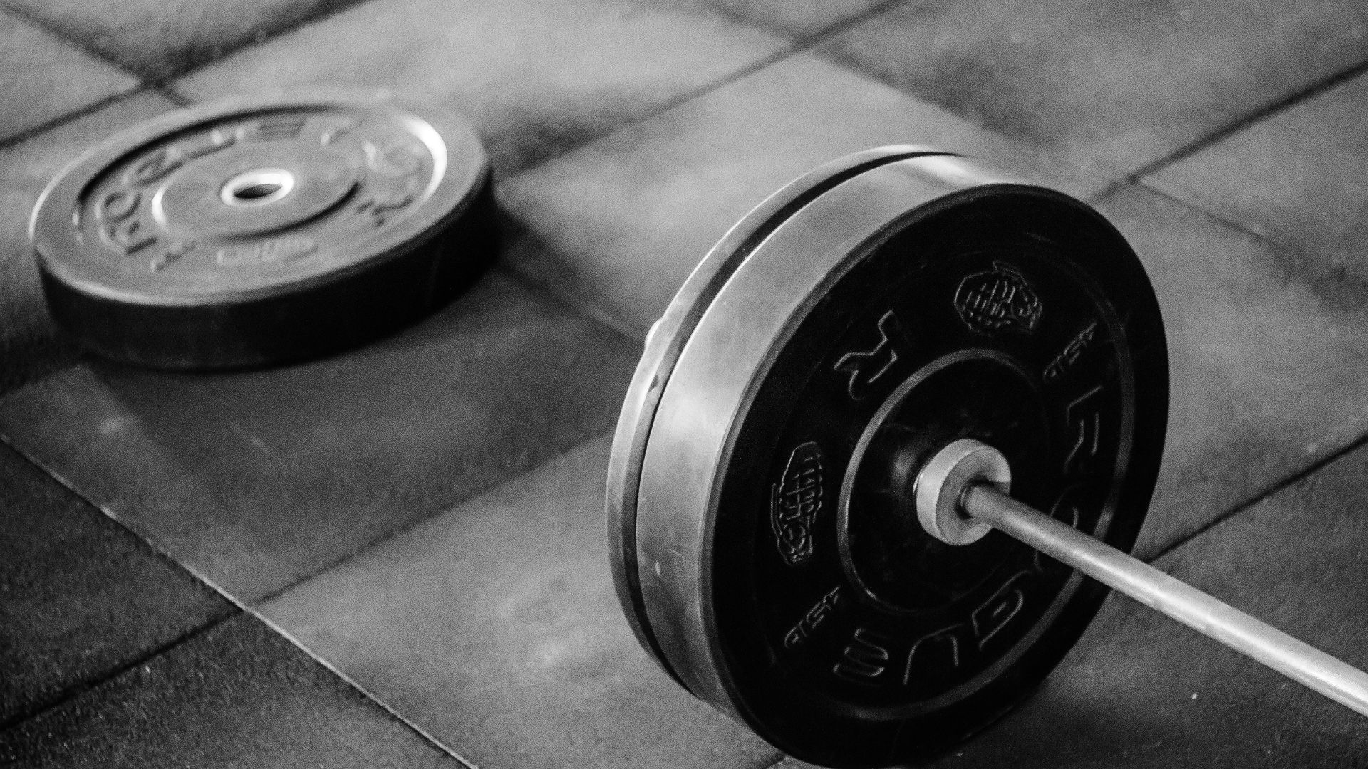 black barbell on tile flooring
