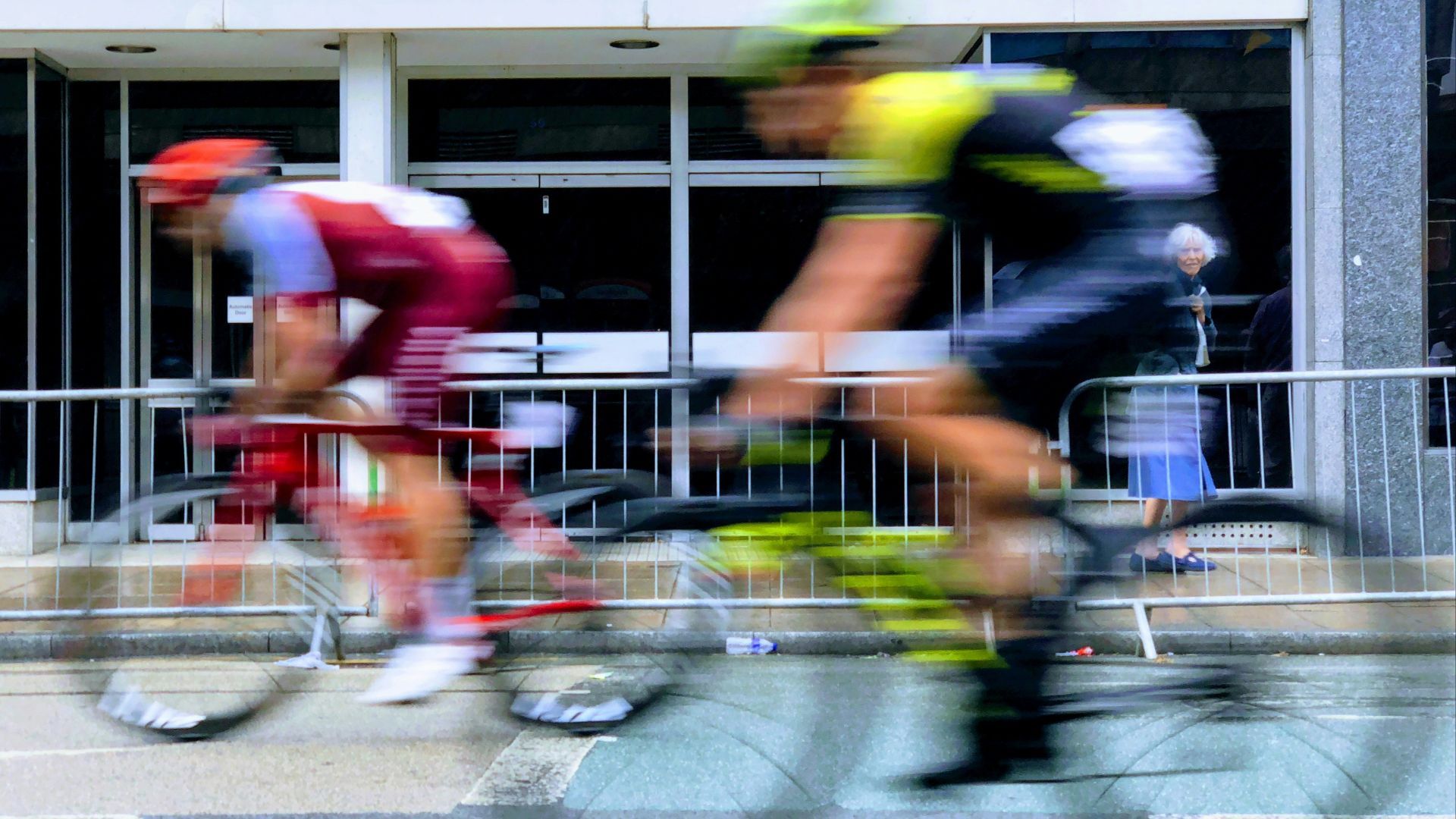 two men riding on black and red road bikes on gray concrete pavement during daytime