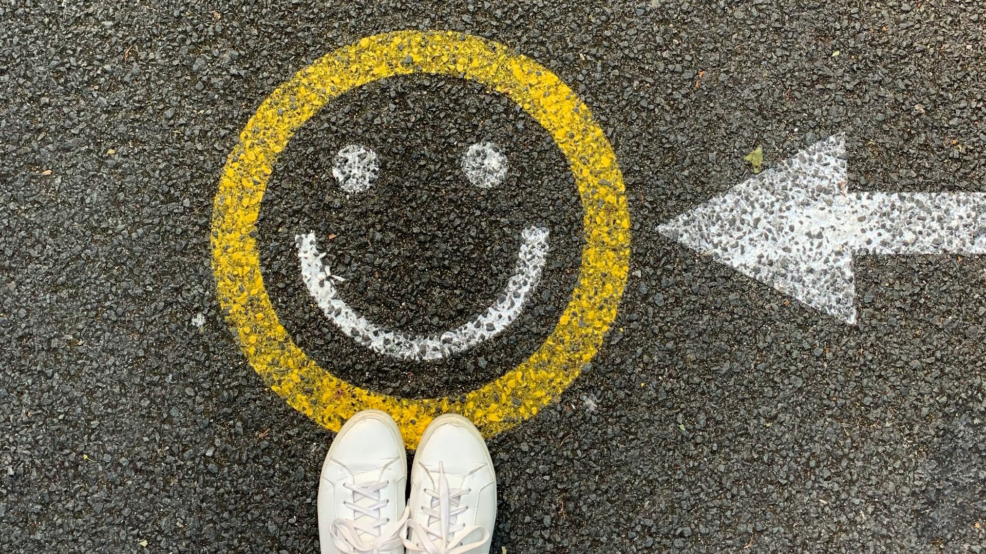 person in white shoes standing on gray concrete road