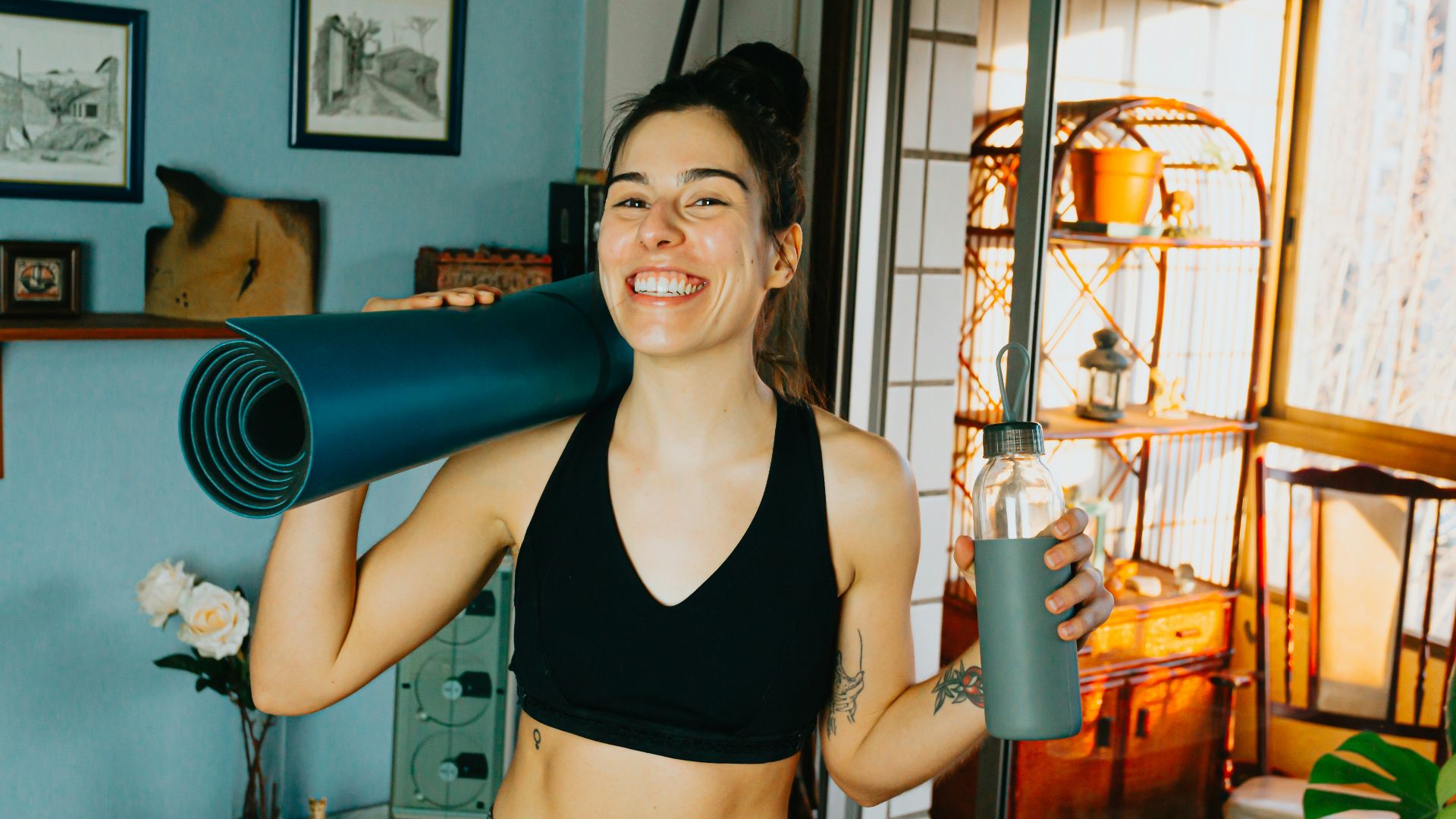 woman in black sports bra holding blue and black kettle