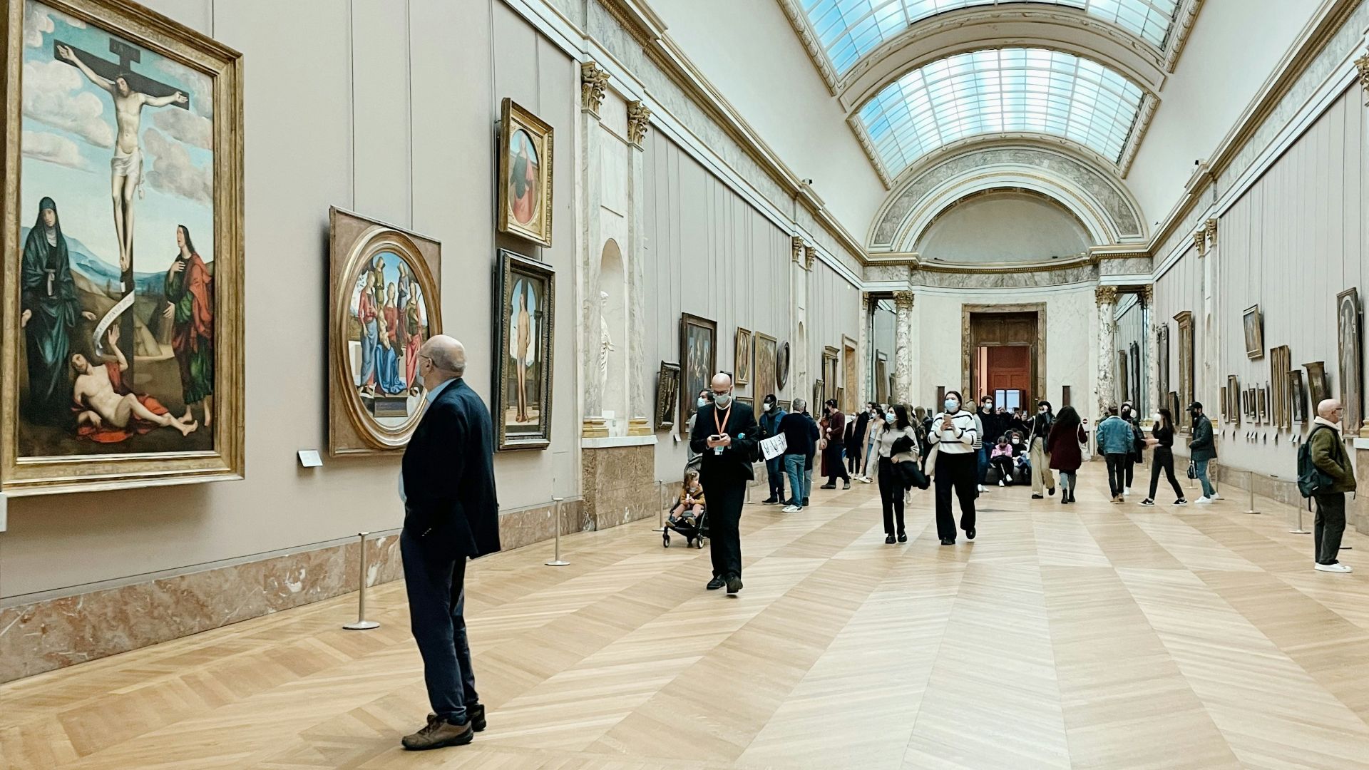 a group of people standing in a room with paintings on the walls